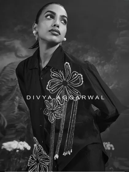 A black and white portrait featuring the Azalea shirt. The focus here is on the bold floral embellishments and the confident, elegant posture they inspire.
