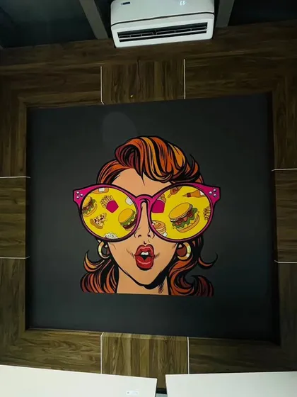 Another example of pop-art for a commercial space. This mural, featuring a woman with food reflected in her sunglasses, is a quirky and stylish choice for a modern eatery.