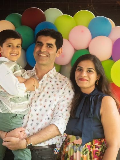 A classic family portrait in front of a festive balloon arch. This shot is perfect for capturing the celebratory mood of a birthday or special event.