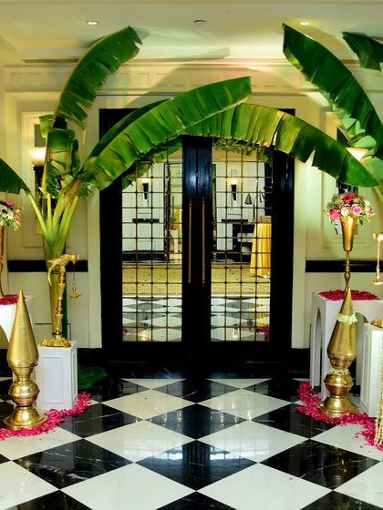 An entrance that honors tradition. I used large banana plantain leaves to frame the doorway, a classic element in South Indian and Maharashtrian weddings, symbolizing prosperity and creating an authentic welcome.