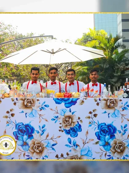 Our team ready to serve behind a beautifully decorated floral bar. We ensure our setup and our staff complement your event's aesthetic perfectly.