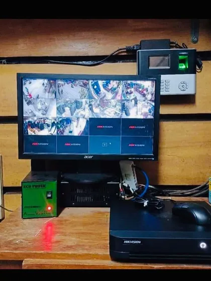 A complete monitoring station setup, including a Hikvision DVR, monitor, and a biometric attendance system. We can integrate multiple security solutions for your office.