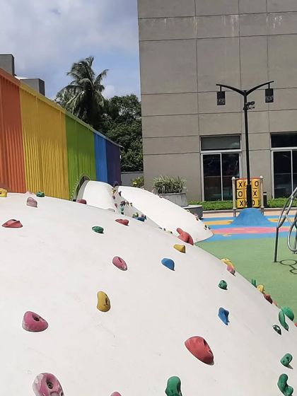 Safety and adventure go hand in hand in our playground designs. This image highlights a custom climbing wall with colorful holds, offering a fun physical challenge for kids within a safe and well-designed play environment.