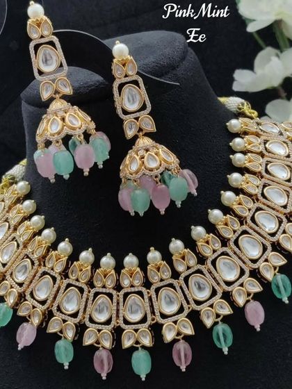 The product shot of the pink and mint Kundan necklace set. This piece is ideal for daytime weddings or for bridesmaids looking for a touch of color.