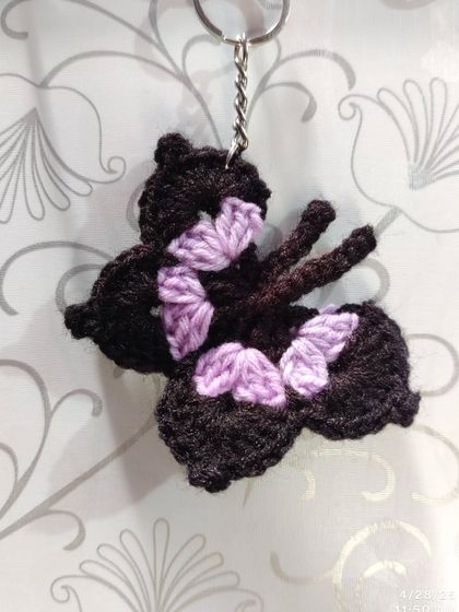 Elegant black butterfly keychains with pops of color like orange, blue, pink, purple, and yellow on the wings.