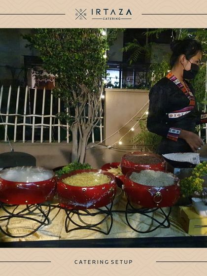 Our staff setting up for an event with our distinctive red tagine pots, ready to serve a delicious and aromatic meal.