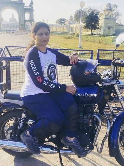 A graduate rider poses with her Royal Enfield in Mysore. Our training gives you the skills to explore new cities and create your own adventures.