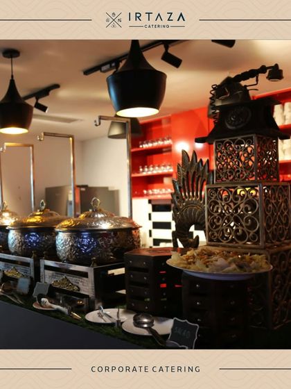 A corporate catering setup in a modern office space. The use of my signature serveware on a sleek counter with industrial-style lighting shows how I can elevate a typical office lunch.