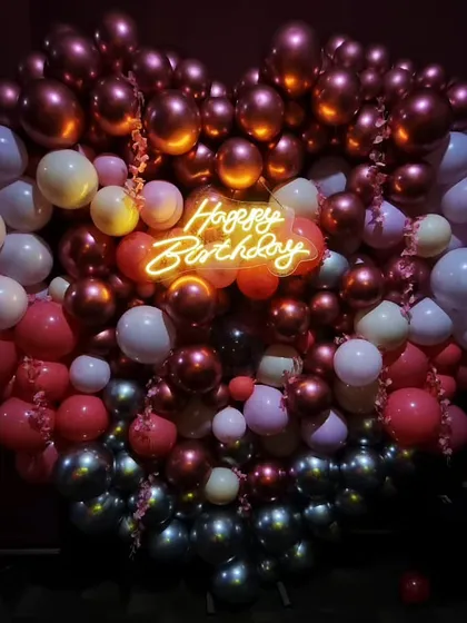 I love creating bold statements like this massive heart-shaped balloon wall. Paired with a glowing 'Happy Birthday' neon sign, this setup in rich metallic tones is guaranteed to be the star of your celebration and your photos.