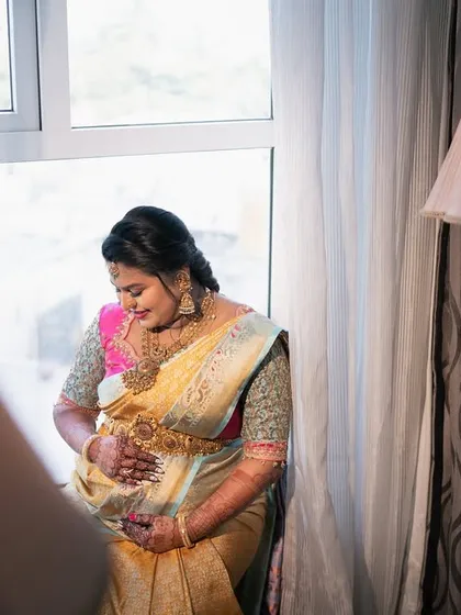 The quiet beauty of a mother-to-be, bathed in soft window light. This portrait captures the serene pregnancy glow and anticipation during her Seemantha.