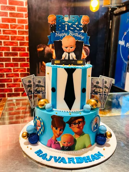 A two-tier Boss Baby cake in a cool blue theme. This design includes edible money and character cutouts, making it a fun and stylish choice for a young fan's birthday.