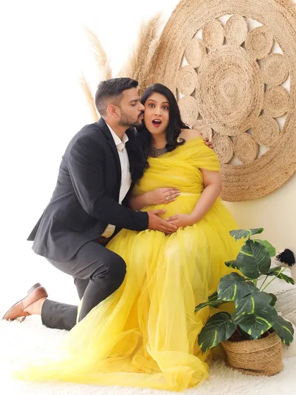 Capturing pure joy and surprise. This fun and candid couple shot in our boho setup, with the mom-to-be in a vibrant yellow gown, is full of life and personality.