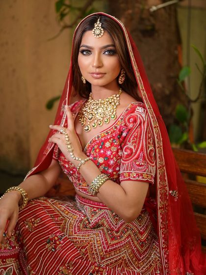 A close-up of the detailed blouse and heavy gold jewellery that accompanies my red bridal lehenga rentals. Every piece is chosen to create a cohesive, royal look.