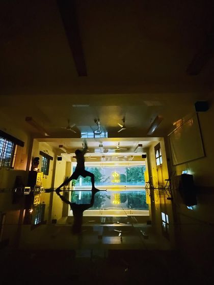 A practitioner in Virabhadrasana (Warrior Pose) at night. It is a blessing to have a practice that connects you to your inner being and enhances your quality of life.