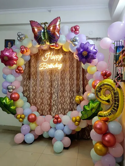 Here is another butterfly-themed decoration I did for a 9th birthday at home. The circular balloon arch uses a soft pastel palette, accented with a large butterfly foil balloon at the top.