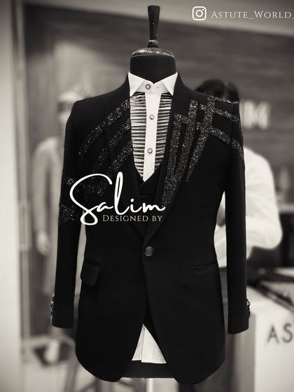 A mannequin displaying a longline tuxedo jacket with asymmetric crystal embellishments. This is a high-fashion piece for someone looking for an avant-garde design.