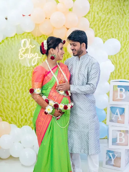 A sweet moment at an "Oh Baby" themed baby shower. The couple looks at each other with so much love, ready to welcome their little one.