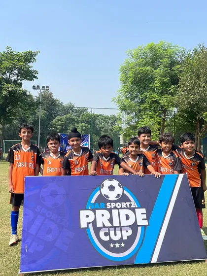 Our U9 team posing behind the Pride Cup banner, ready to compete.