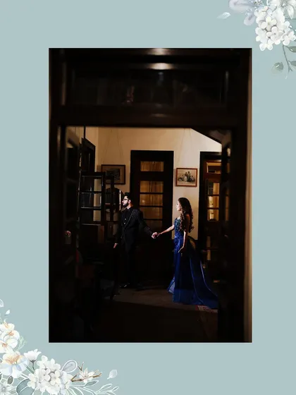 An atmospheric shot of the couple, framed by a doorway. The low light and their hand-in-hand pose create a sense of intimacy and romance.