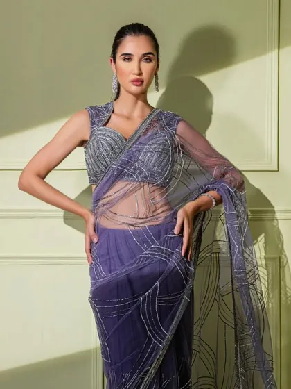 A beautiful purple net saree with abstract silver embroidery. The sheer fabric and structured blouse create a look that is both delicate and powerful.