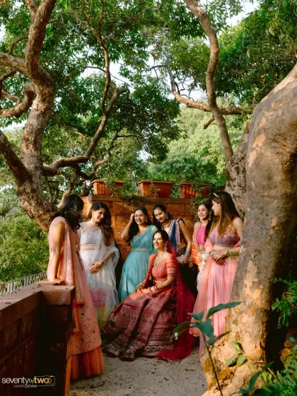 The bride surrounded by her bridesmaids, sharing a laugh under the shade of an ancient, gnarled tree in Mahabaleshwar. A beautiful, natural portrait of friendship.