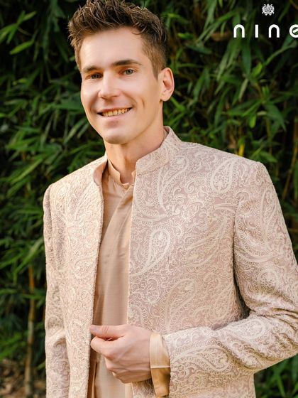 A close-up of our handcrafted open sherwani, showing the beautiful texture of the fabric. Paired with a simple kurta, this ensemble brings a touch of old-world Mughal elegance to any celebration.