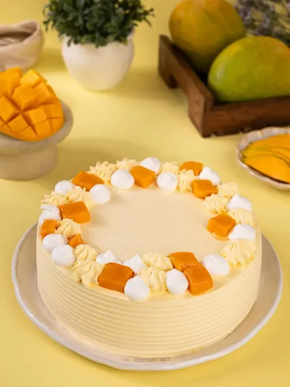 A beautifully decorated mango cream cake. The clean lines and simple decorations give it a very professional and elegant look, perfect for a bakery's menu.