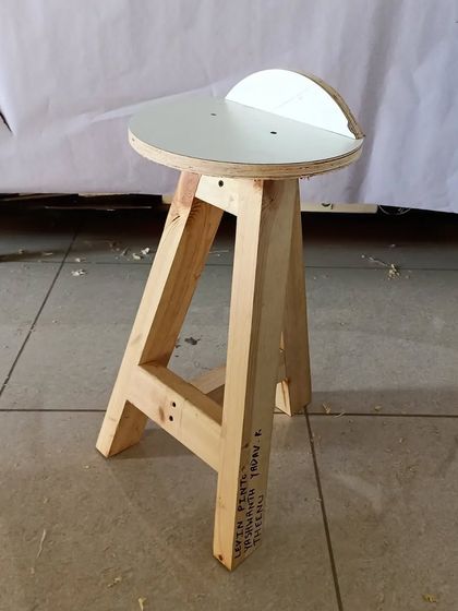 A tripod stool with a circular top, made by students during an intercollegiate design event. It's a classic design that is both stable and stylish.