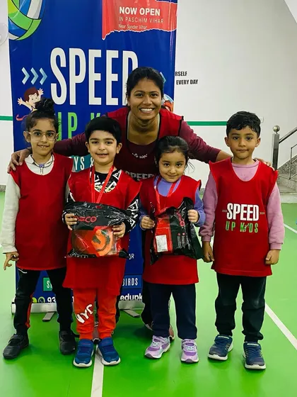 Nyra Khaneja, another one of our 'Most Valuable Kids of the Month', posing with her friends and coach.