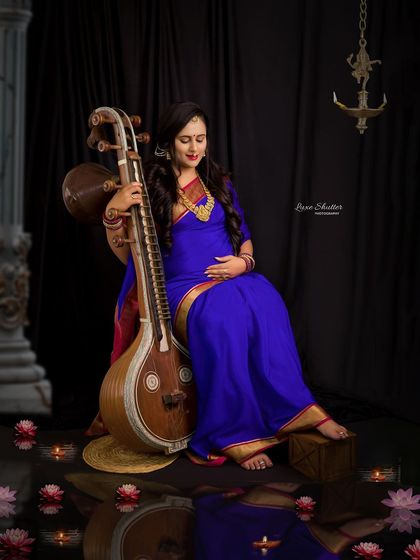 A beautifully lit portrait that feels both traditional and divine. The candles at her feet and the classical props create a serene and spiritual atmosphere.