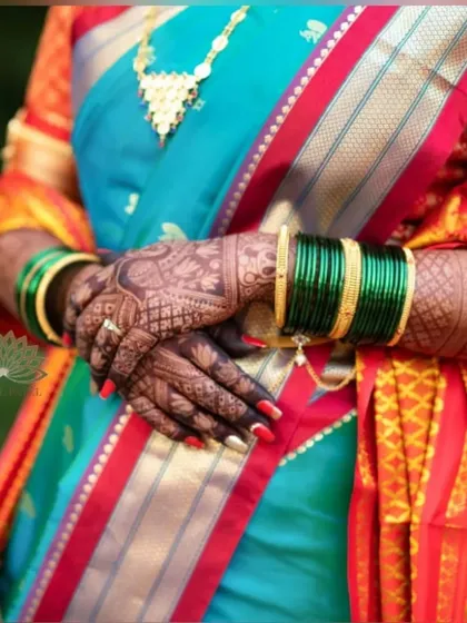 A close-up of the bride's hands, showing the beautiful mehndi stain against her colorful saree. The contrast is stunning.
