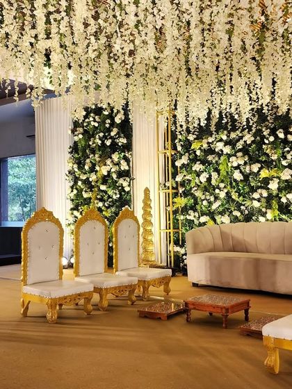 A side view of the lush green reception stage, highlighting the depth created by the golden frame and the layers of florals.