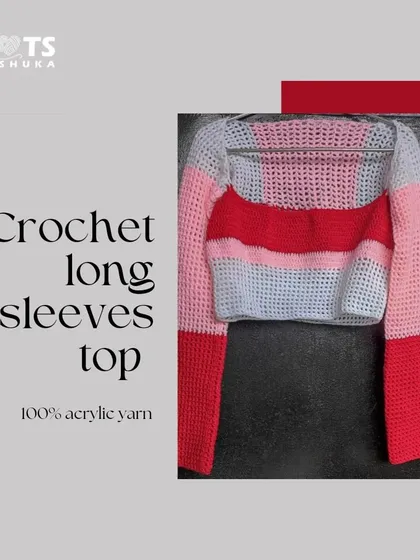 A flat lay of one of my long-sleeved crop tops. This one features bold red, pink, and white stripes and is made from cozy acrylic yarn.