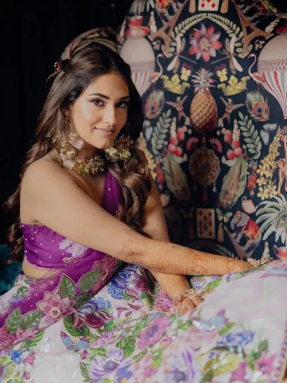 A modern bride in a floral lehenga, looking fresh and beautiful for her Mehendi ceremony.