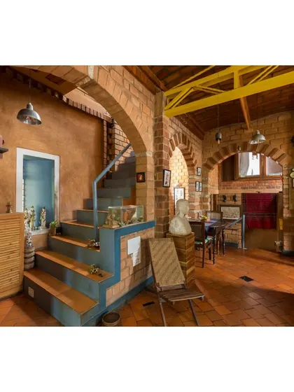 The multi-level interior of the Sans Souci Residence, showing how we play with levels to create connected yet private spaces. The staircase and arches, built with compressed earth blocks, define the home's character while ensuring natural light and ventilation.