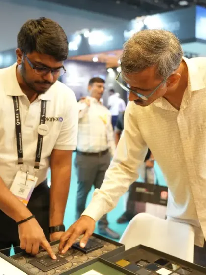 An exhibitor demonstrates the fine details of a smart switch panel to an interested architect. These interactions are key for showcasing product design and functionality to decision-makers.