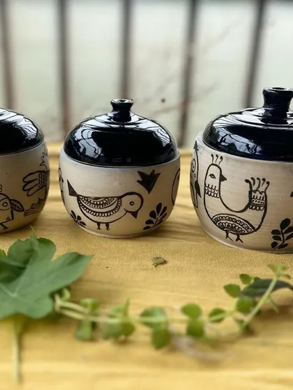 These little lidded jars are fresh from the kiln. I love the contrast between the glossy black lids and the hand-drawn bird illustrations on the raw clay. They are perfect for storing spices, trinkets, or just to admire on a shelf.
