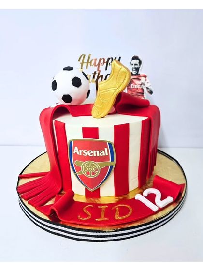 For the dedicated young fan, this Arsenal-themed football cake is a sure winner. It features the team's iconic red and white stripes, the club crest, and a golden boot topper.