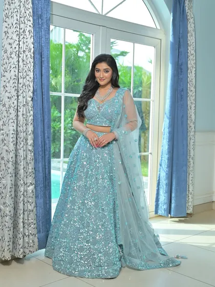 An ethereal look for a reception or cocktail event. This model wears a shimmering light blue lehenga, beautifully accessorized with a multi-layered zircon necklace that sparkles from every angle.
