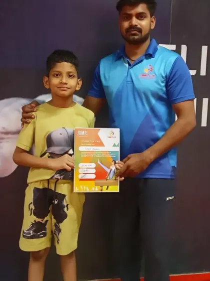 This student proudly holds his "JUMP" program certificate, recognizing his hard work and new skills.