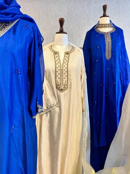 A closer view of the contrast between the bold blue and the serene ivory, highlighting the different embroidery patterns on each neckline.