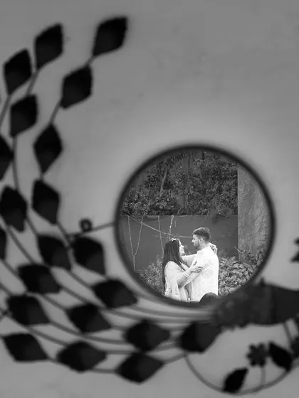An artistic black and white shot capturing the reflection of the couple in a mirror. It’s a creative way to frame their intimacy and connection.