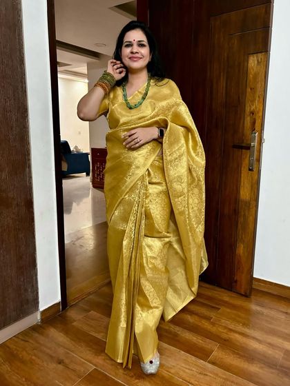 This golden tissue saree is a showstopper. It's perfect for weddings and big celebrations. It's a timeless piece that always makes me feel glamorous.