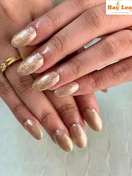 Perfect for the festive season. These oval-shaped nails are fully coated in a brilliant gold glitter polish, making your hands the center of attention.