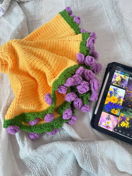 The bouquet blanket, partially unfurled. This image shows the transition from a bouquet shape to a functional, round blanket with a floral border.