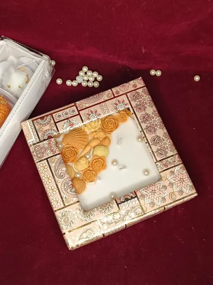 A single seashell-themed urli candle in a decorative gift box.