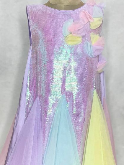 Our "Pari" dress in a beautiful pastel rainbow and purple sequin combination. The 3D floral details on the shoulder add an extra touch of whimsy.
