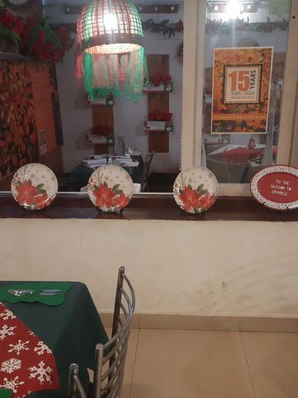 Christmas-themed plates line the windowsill, adding to the festive charm of the cafe.