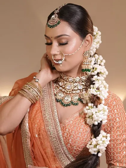 A full view of the bride's hairstyle, a long, thick braid beautifully decorated with fresh gajra. This is a classic and elegant choice for any traditional bride.