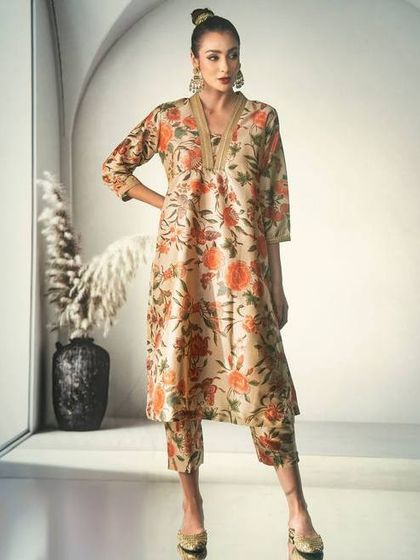 A clean, modern take on ethnic fashion. The projected background provides a simple architectural element that allows the floral print and the model's powerful pose to take center stage.